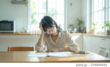 頭を抱えて悩む女性 頭を抱えて悩む女性 134844442