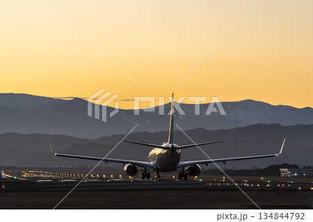 夕暮れの仙台空港　離陸中の飛行機　宮城県名取市 134844792