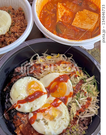 Bibimbap, a vibrant Korean rice dish topped with a variety of seasoned vegetables, gochujang, and a fried egg, often accompanied by sliced meat. Mixed together, it creates a flavorful and balanced. Bibimbap, a vibrant Korean rice dish topped with a variety of seasoned vegetables, gochujang, and a fried egg, often accompanied by sliced meat. Mixed together, it creates a flavorful and balanced. 134846733