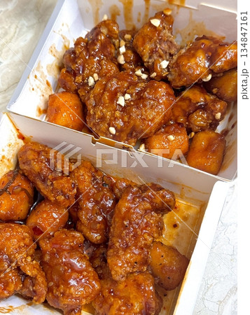 Crispy Korean fried chicken, perfectly glazed with a sweet and spicy sauce. Ideal for food photography and menus, showcasing the irresistible crunch and flavor of this beloved dish. 134847161