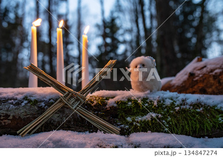 Wiccan altar for Imbolc holiday. Brigids cross of straw, candles, witch doll ram/sheep on snow. witchcraft, magic pagan ritual. 134847274