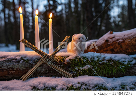 Wiccan altar for Imbolc holiday. Brigids cross of straw, candles, witch doll ram/sheep on snow. witchcraft, magic pagan ritual. 134847275