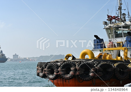 台湾、高雄港のタグボート、古タイヤの列と青い海面、青い空、船橋が厳しい、 134848964