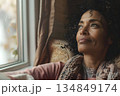 Close-up of a woman sitting on sofa near window 134849174