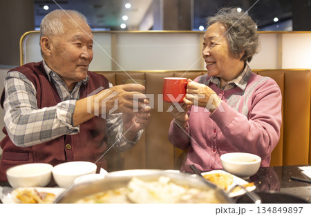 Happy Asian senior couple celebrating Chinese New Year in restaurant 134849897
