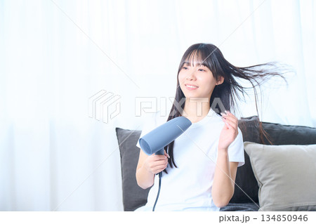 明るいリビングでドライヤーを使う日本人女性 134850946