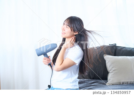 明るいリビングでドライヤーを使う日本人女性 134850957