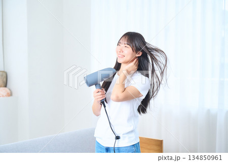 明るいリビングでドライヤーを使う日本人女性 134850961