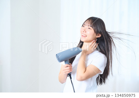 明るいリビングでドライヤーを使う日本人女性 134850975
