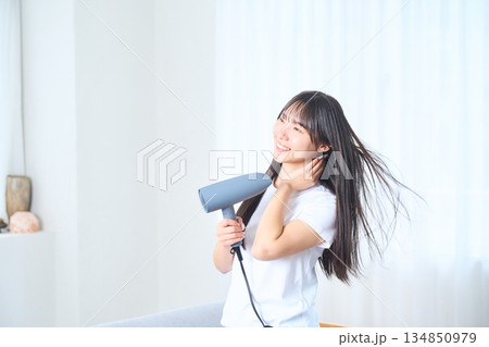 明るいリビングでドライヤーを使う日本人女性 134850979