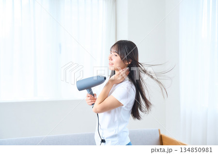 明るいリビングでドライヤーを使う日本人女性 134850981