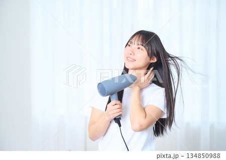 明るいリビングでドライヤーを使う日本人女性 134850988