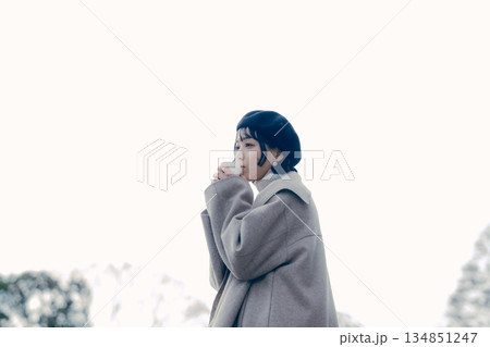 屋外でコーヒーを飲む30代女性のライフスタイルポートレート 134851247