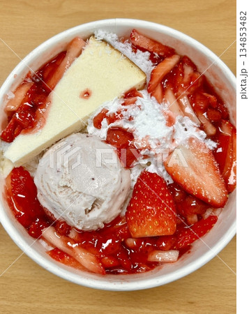 Soft and fluffy strawberry bingsu with finely shaved ice, sweet strawberry syrup, and fresh strawberry slices. A refreshing and delightful Korean dessert, perfect for a cool and fruity treat. 134853482