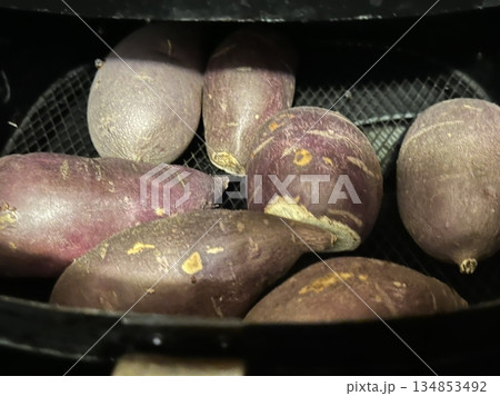 Raw sweet potatoes with smooth, earthy skin and vibrant orange flesh, ready for cooking or baking. Perfect for making nutritious meals or snacks. 134853492