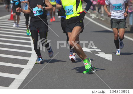 マラソン大会で快走する市民ランナーの足元とランニングシューズの躍動感 134853991