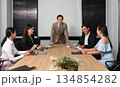 Confident male leader address business team in meeting and fostering engagement and collaboration for business strategy planning around conference table with laptop and documents 134854282