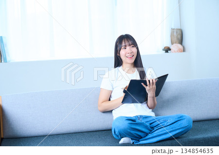 ノートを開いて考え事をする日本人女性 アイデア・将来設計・勉強のイメージ ノートを開いて考え事をする日本人女性 アイデア・将来設計・勉強のイメージ 134854635