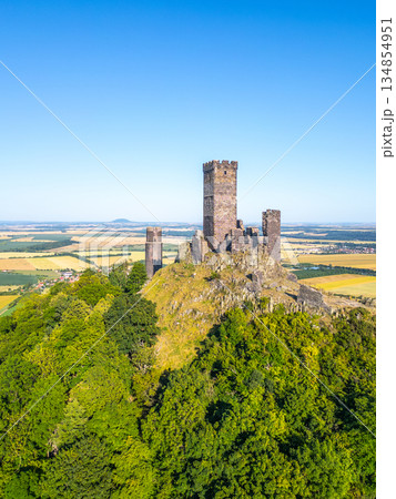 Hazmburk castle ruins rise majestically in Czechia's Central Bohemian Uplands. This medieval marvel offers breathtaking views over the lush green hills and fields below. Hazmburk castle ruins rise majestically in Czechia's Central Bohemian Uplands. This medieval marvel offers breathtaking views over the lush green hills and fields below. 134854951