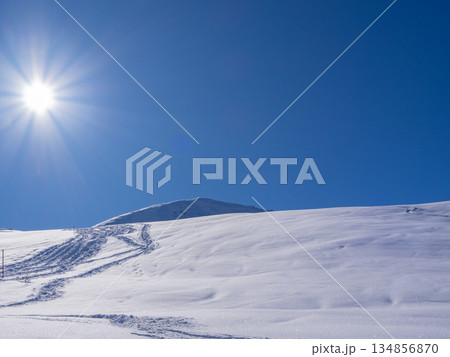 Praettigau, Switzerland - February 15th 2025: A snowshoe trail leading through an alpine winter landscape 134856870