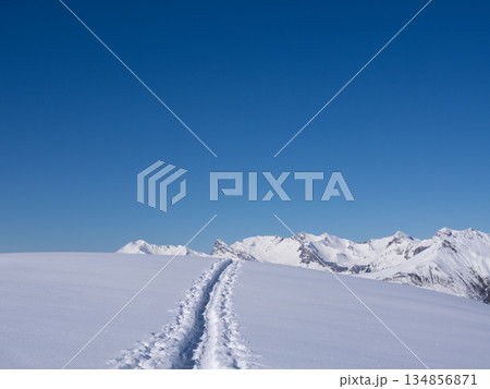 Praettigau, Switzerland - February 15th 2025: View along a snowshoe trail leading through an alpine winter landscape Praettigau, Switzerland - February 15th 2025: View along a snowshoe trail leading through an alpine winter landscape 134856871