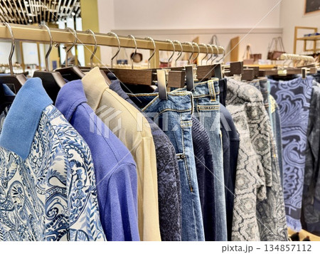 men's polo shirts and jeans are hanging on a hanger in a clothing store men's polo shirts and jeans are hanging on a hanger in a clothing store 134857112