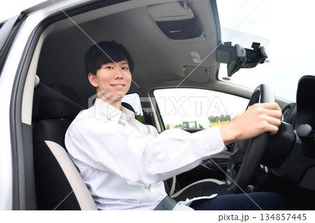 車を運転する笑顔のアジア人男性ドライバー 車を運転する笑顔のアジア人男性ドライバー 134857445