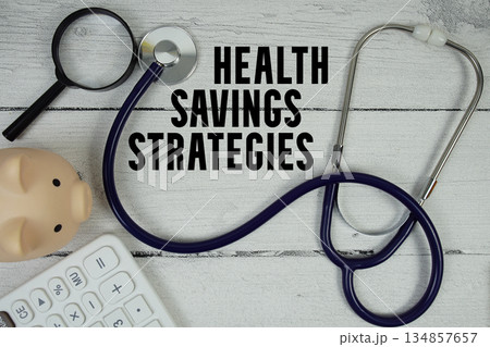 Health Savings Strategies text with Stethoscope and magnifying glass on wooden background Health Savings Strategies text with Stethoscope and magnifying glass on wooden background 134857657