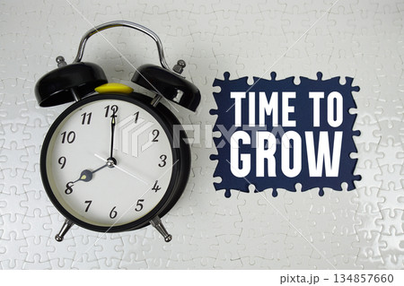 Time to Grow text with alarm clock on navy blue background Time to Grow text with alarm clock on navy blue background 134857660