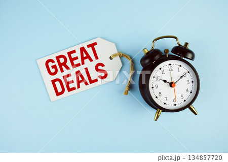 Great Deals text on price tag with alarm clock on blue background 134857720