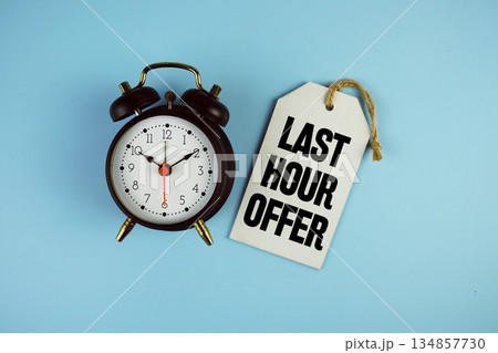 Last Hour Offer text on price tag with alarm clock on blue background Last Hour Offer text on price tag with alarm clock on blue background 134857730