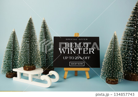 End of Year Sale 25% off text with easel and Christmas tree on blue background 134857743