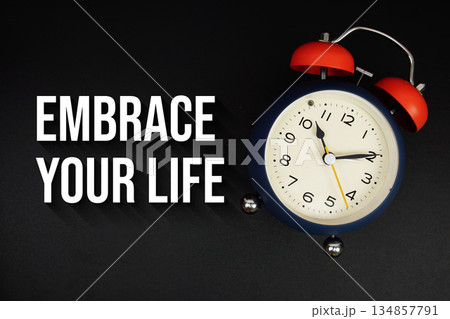 Embrace Your Life text with alarm clock on black background Embrace Your Life text with alarm clock on black background 134857791