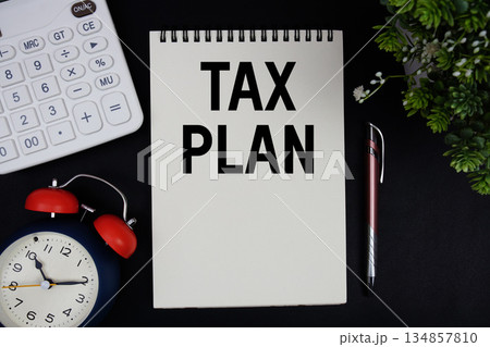 Tax Plan text with calculator with alarm clock on black background 134857810