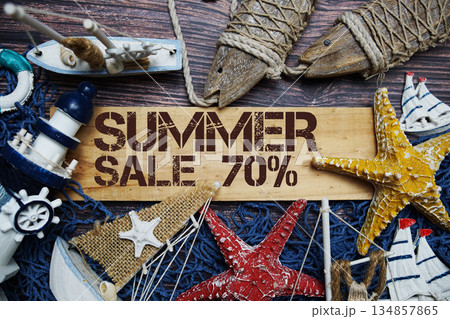 Summer Sale 70% off text on wooden sign decorated with marine nautical on a wooden background 134857865