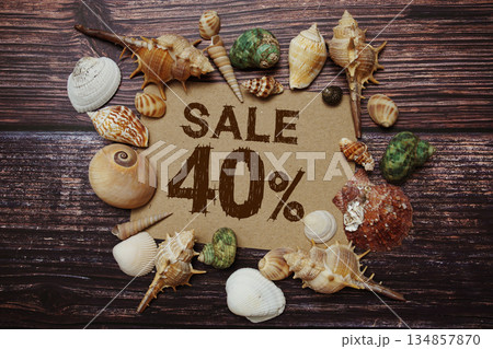 Sale 40% off sign decorated with seashells on a wooden background 134857870