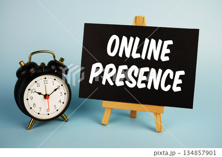 Online Presence text with easel and alarm clock on blue background Online Presence text with easel and alarm clock on blue background 134857901