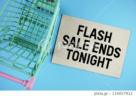 Flash Sale Ends Tonight text on paper card with trolley shopping cart on blue background 134857912
