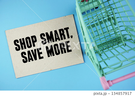 Shop Smart, Save More text on paper card with trolley shopping cart on blue background 134857917