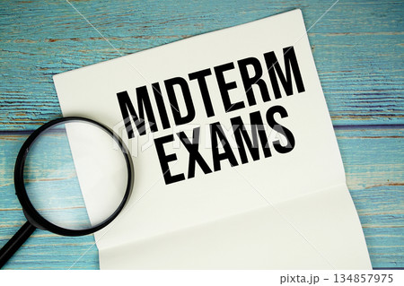 Midterm Exams text written on notepad with magnifying glass flat lay on wooden background Midterm Exams text written on notepad with magnifying glass flat lay on wooden background 134857975