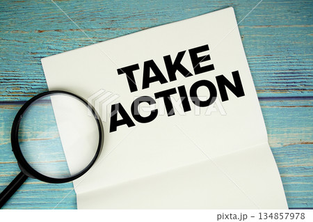 Take Action text written on notepad with magnifying glass flat lay on wooden background Take Action text written on notepad with magnifying glass flat lay on wooden background 134857978