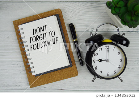 Don't Forget To Follow Up text written on notepad with alarm clock on wooden background Don't Forget To Follow Up text written on notepad with alarm clock on wooden background 134858012