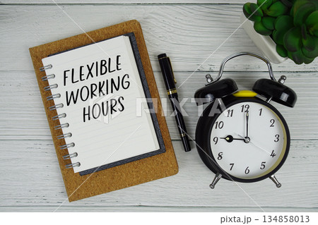 Flexible Working Hours text written on notepad with alarm clock on wooden background Flexible Working Hours text written on notepad with alarm clock on wooden background 134858013