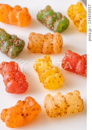 Colorful gummy bears with chili lime seasoning displayed on clean white plate 134858057