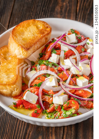 Roasted red pepper salad with feta red onion herbs and toasted crostini 134858063