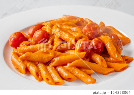Penne pasta with roasted bell pepper emulsion cherry tomatoes Parmesan and herbs 134858064