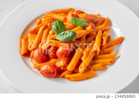 Penne pasta with roasted bell pepper emulsion cherry tomatoes Parmesan and herbs 134858065