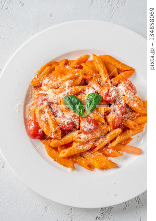 Penne pasta with roasted bell pepper emulsion cherry tomatoes Parmesan and herbs 134858069