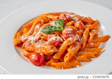 Penne pasta with roasted bell pepper emulsion cherry tomatoes Parmesan and herbs 134858070