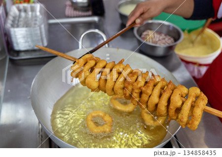A woman is cooking picarones in a pan 134858435